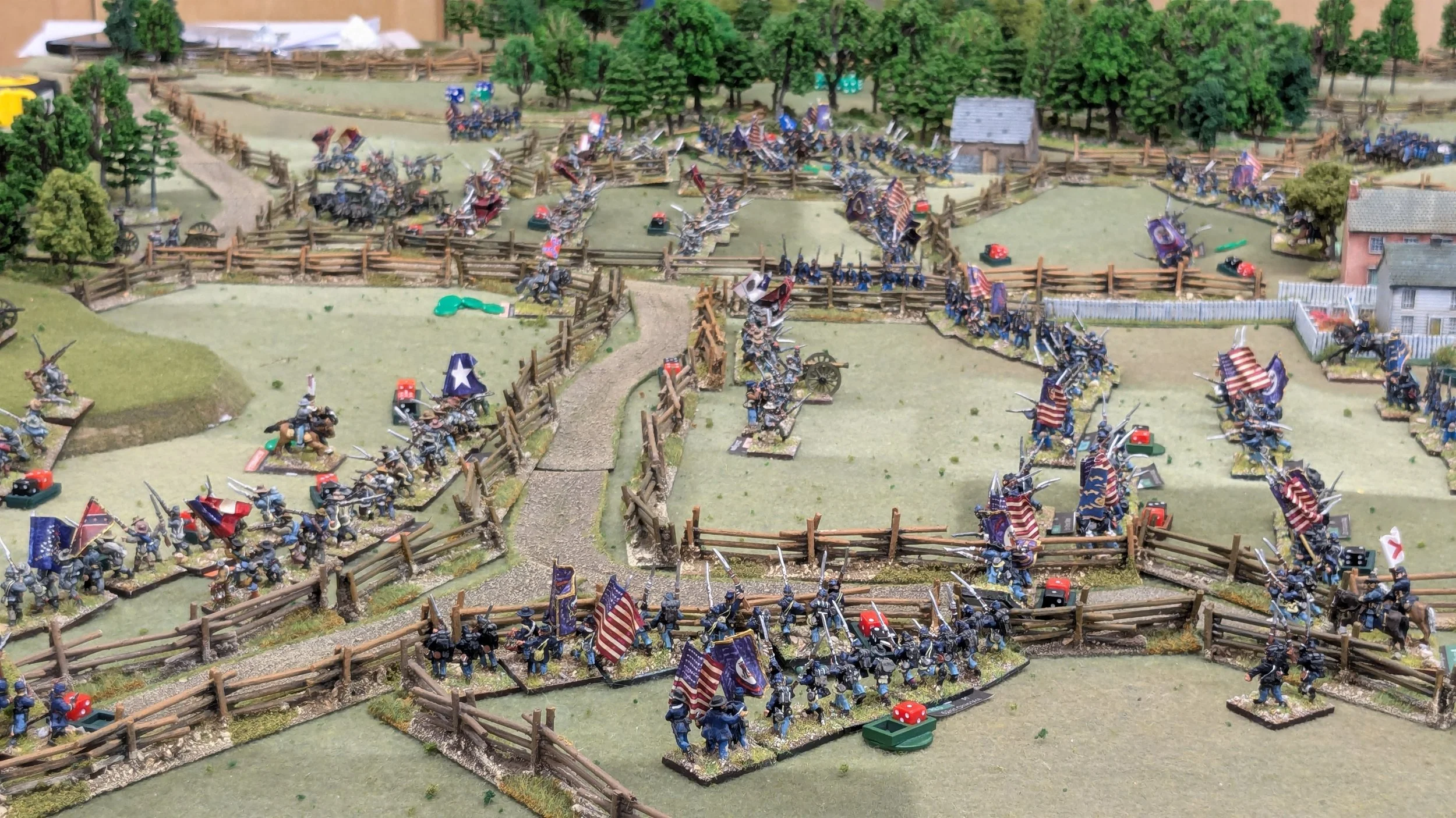 Miniature diorama of a Civil War battlefield with Union soldiers, fences, trees, and buildings.