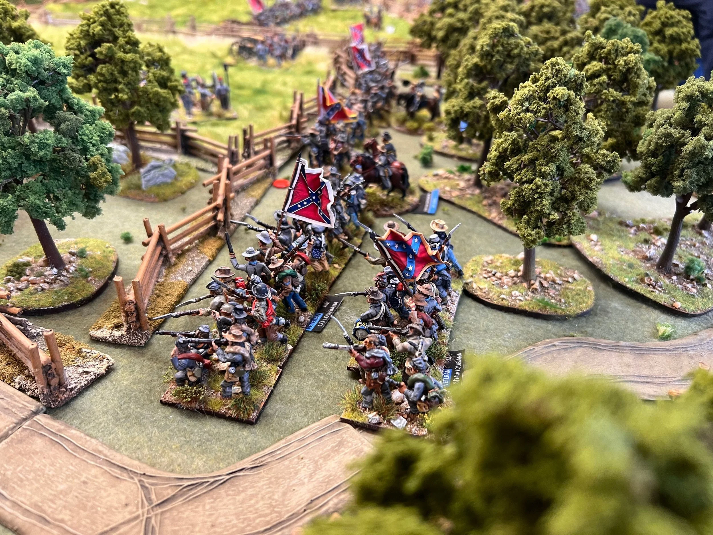 Miniature scene depicting Civil War soldiers in formation, carrying flags, set in a landscape with trees and fencing.