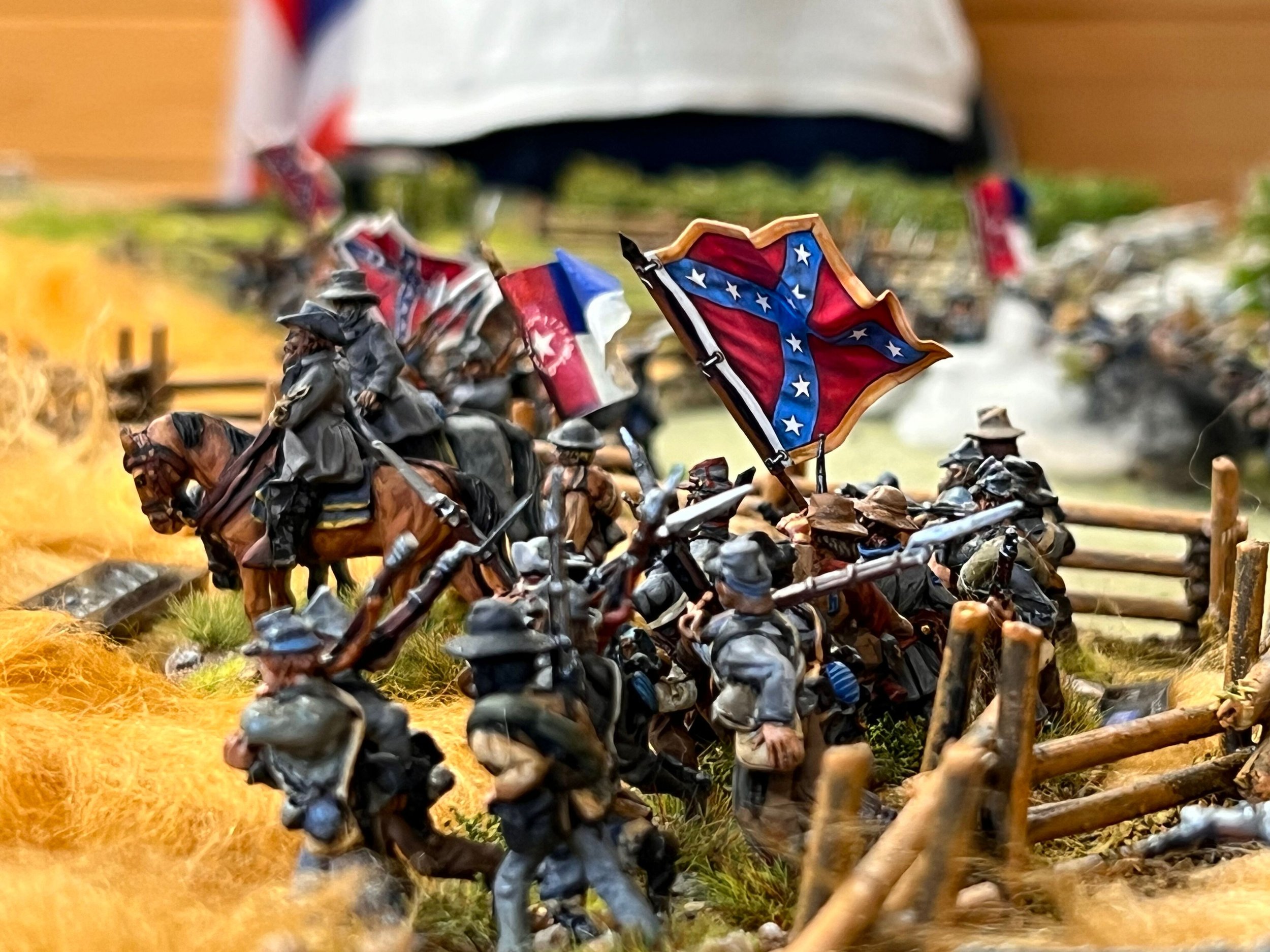 Miniature soldiers with American flags fighting on a battlefield.