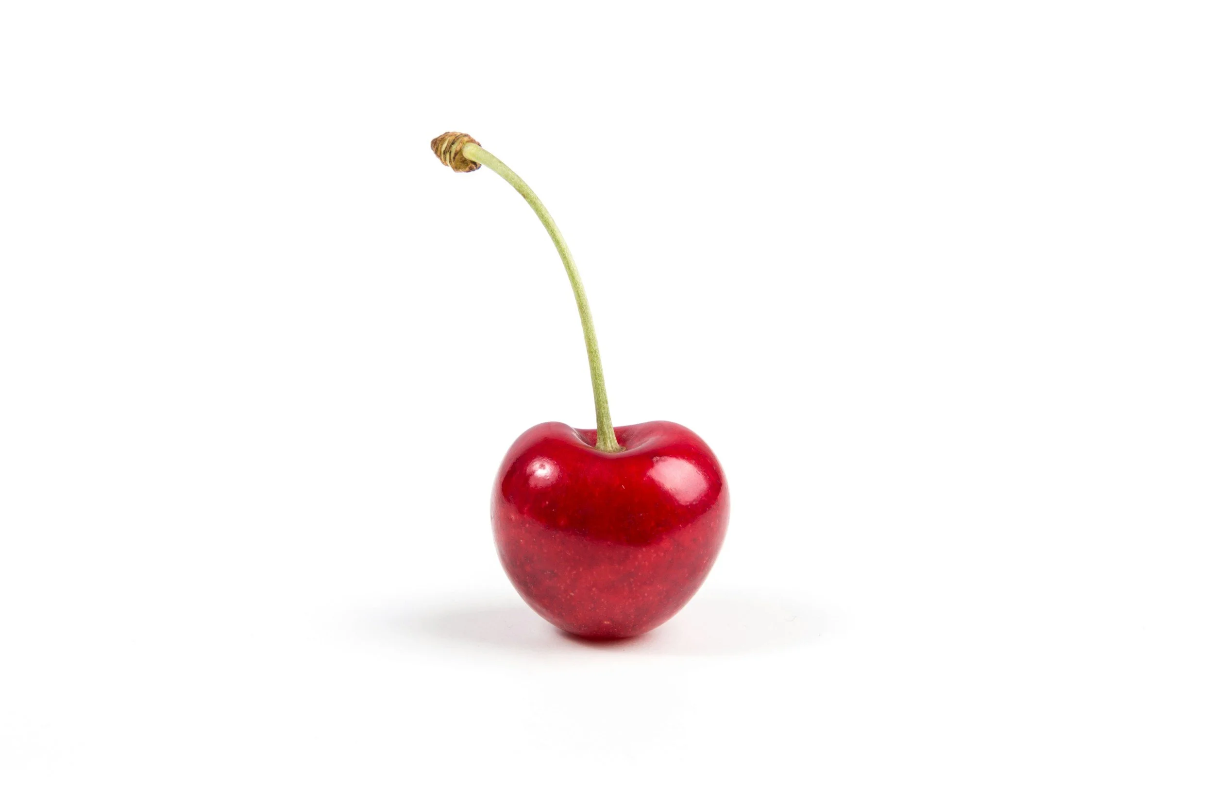 A single red cherry with a green stem and a small brown cap, isolated on a white background.
