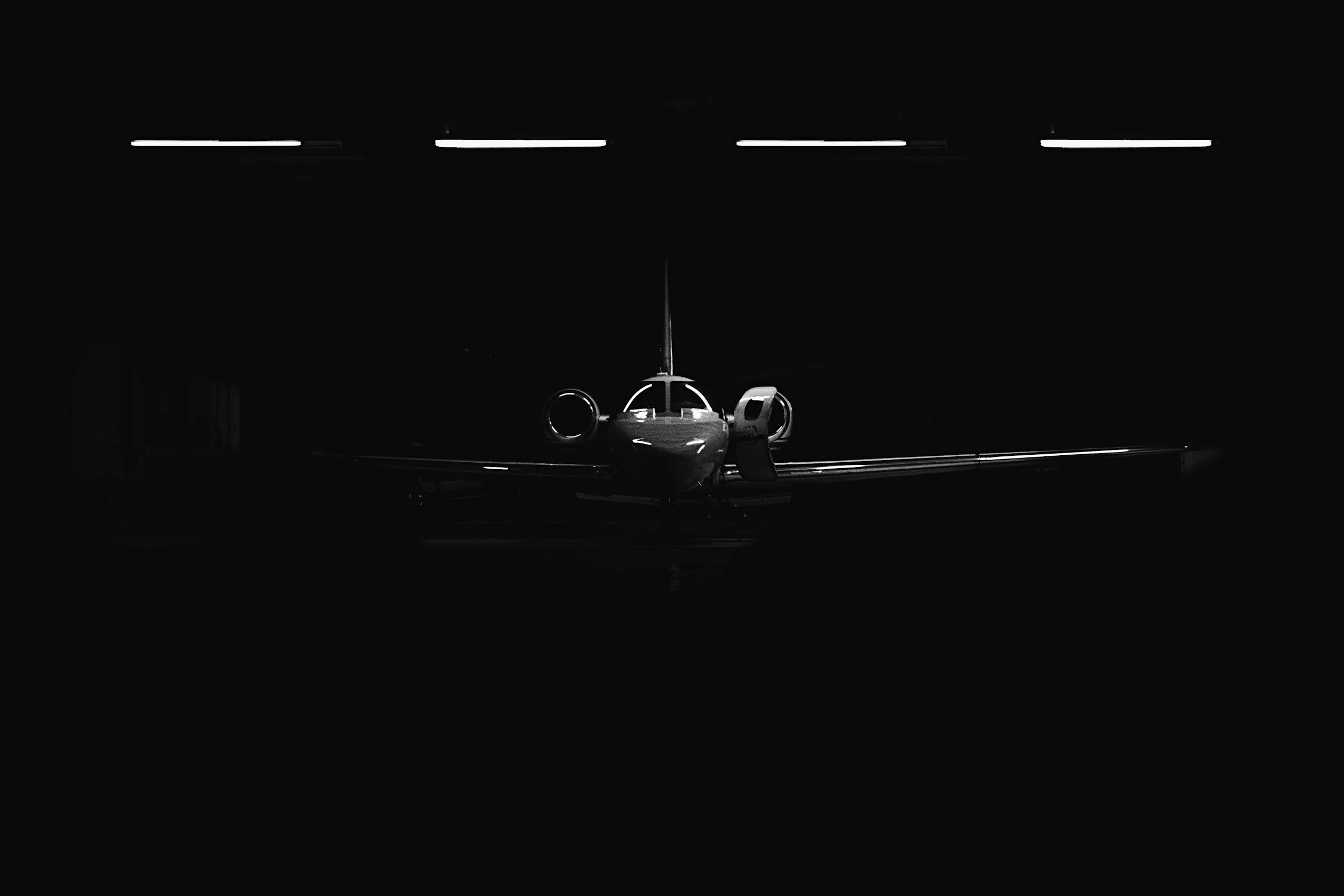 A small airplane positioned on a runway in a dark environment with minimal lighting.