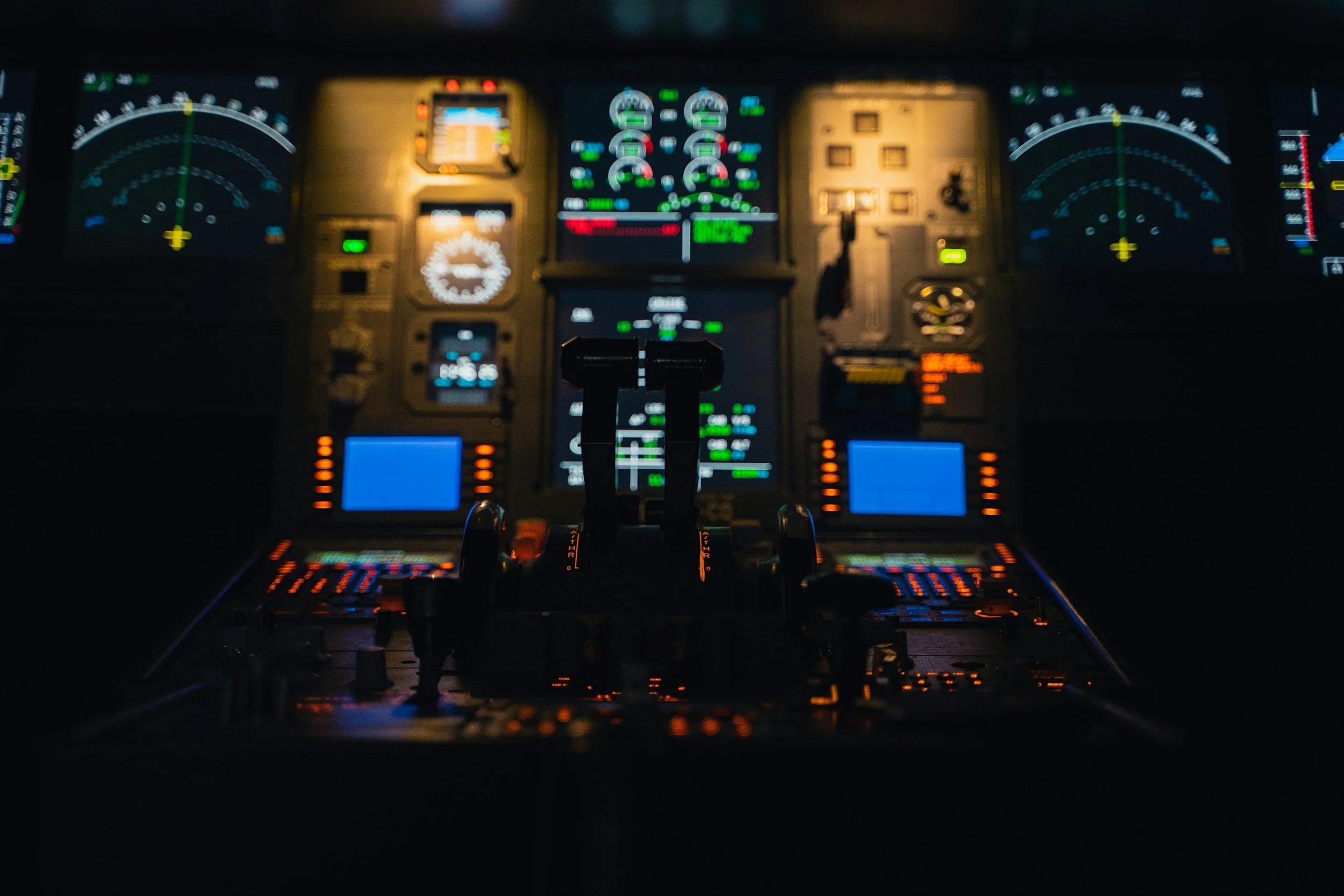 A blurry photo of an aircraft cockpit dashboard with various illuminated instruments and gauges.
