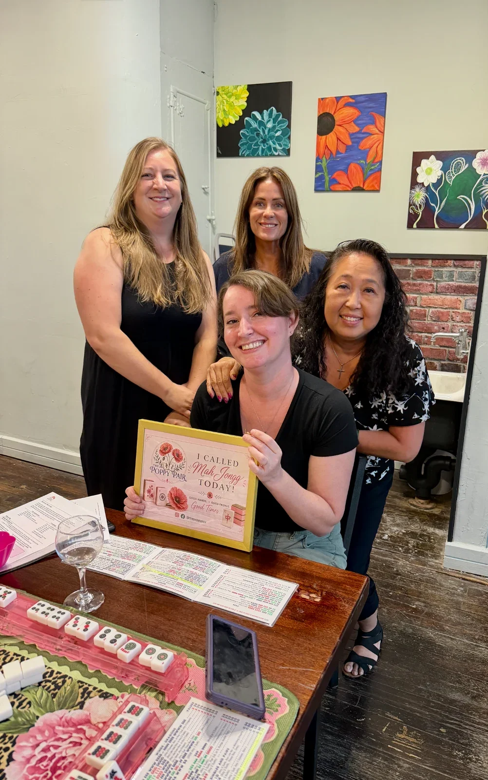 Four women at a Poppy Pair American Mah Jongg class at Blend of Seven Winery in Marion, Ohio, celebrating an “I Called Mah Jongg Today!” certificate.