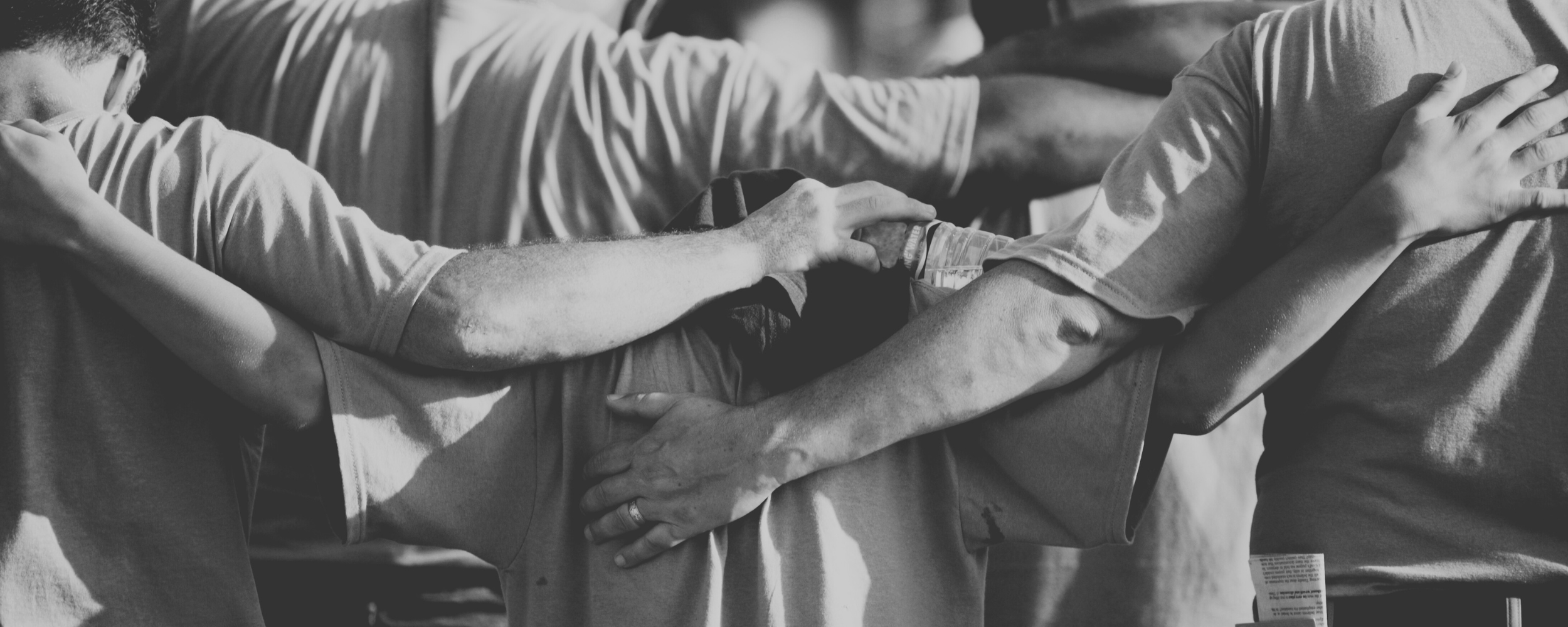 A group of people lying hugging and supporting one another.