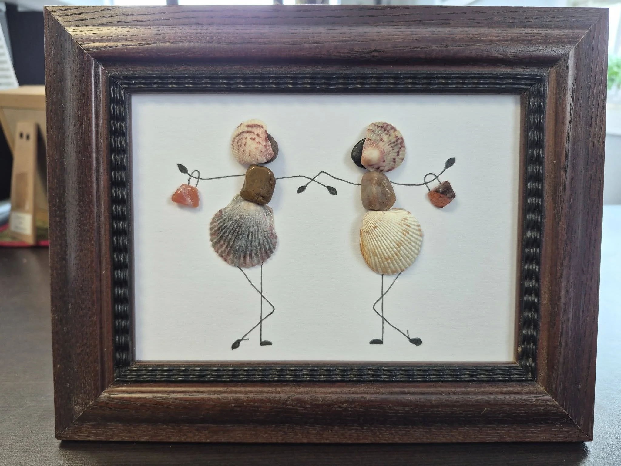 Handmade seashell and pebble dancing figures artwork