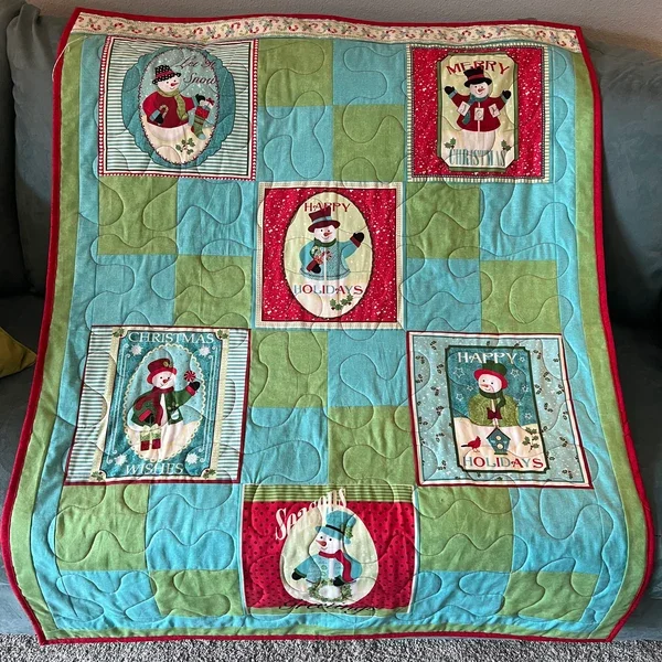 Handmade holiday quilt with snowman panels and colorful patchwork squares