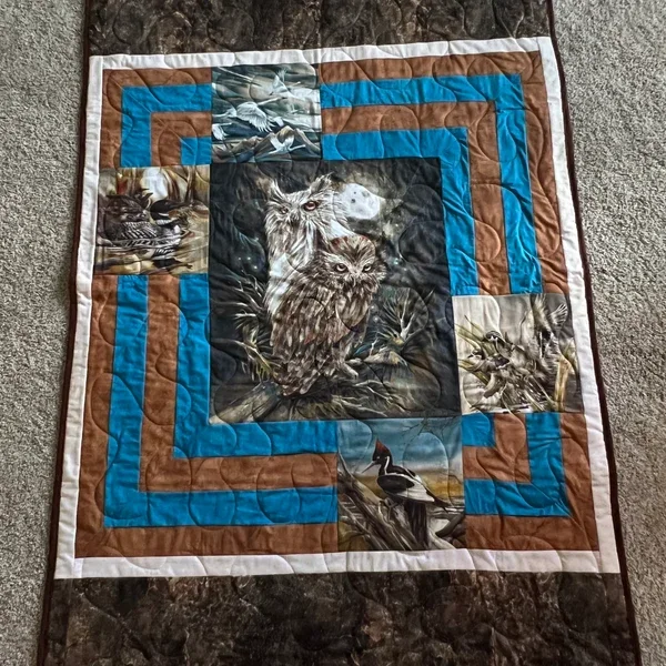 Handmade wildlife quilt featuring owl and bird panels with layered borders