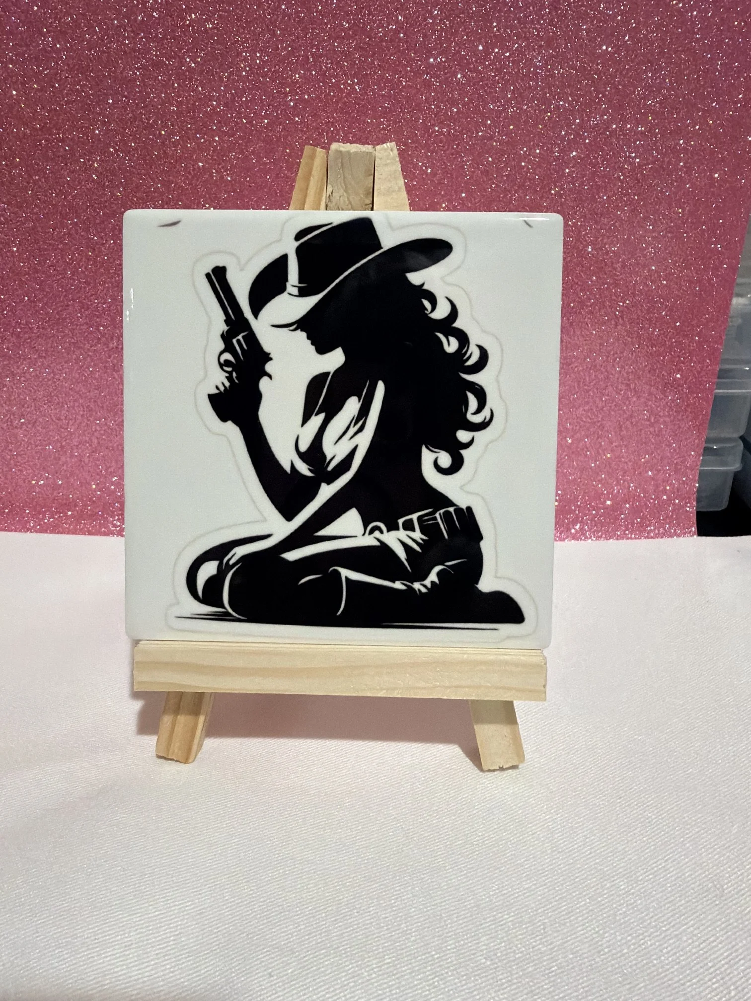 Decorative silhouette art tile displayed on a small easel.