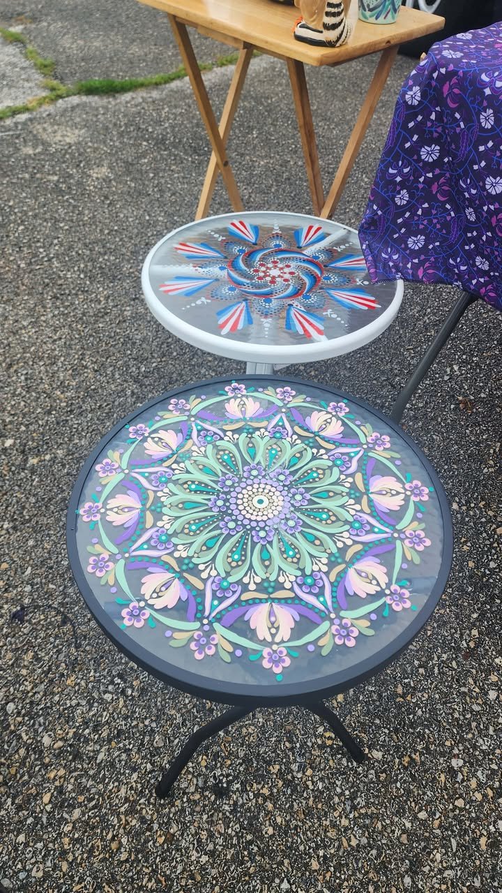 Round accent table with a detailed floral mandala design painted in green, purple, pink, and teal tones.