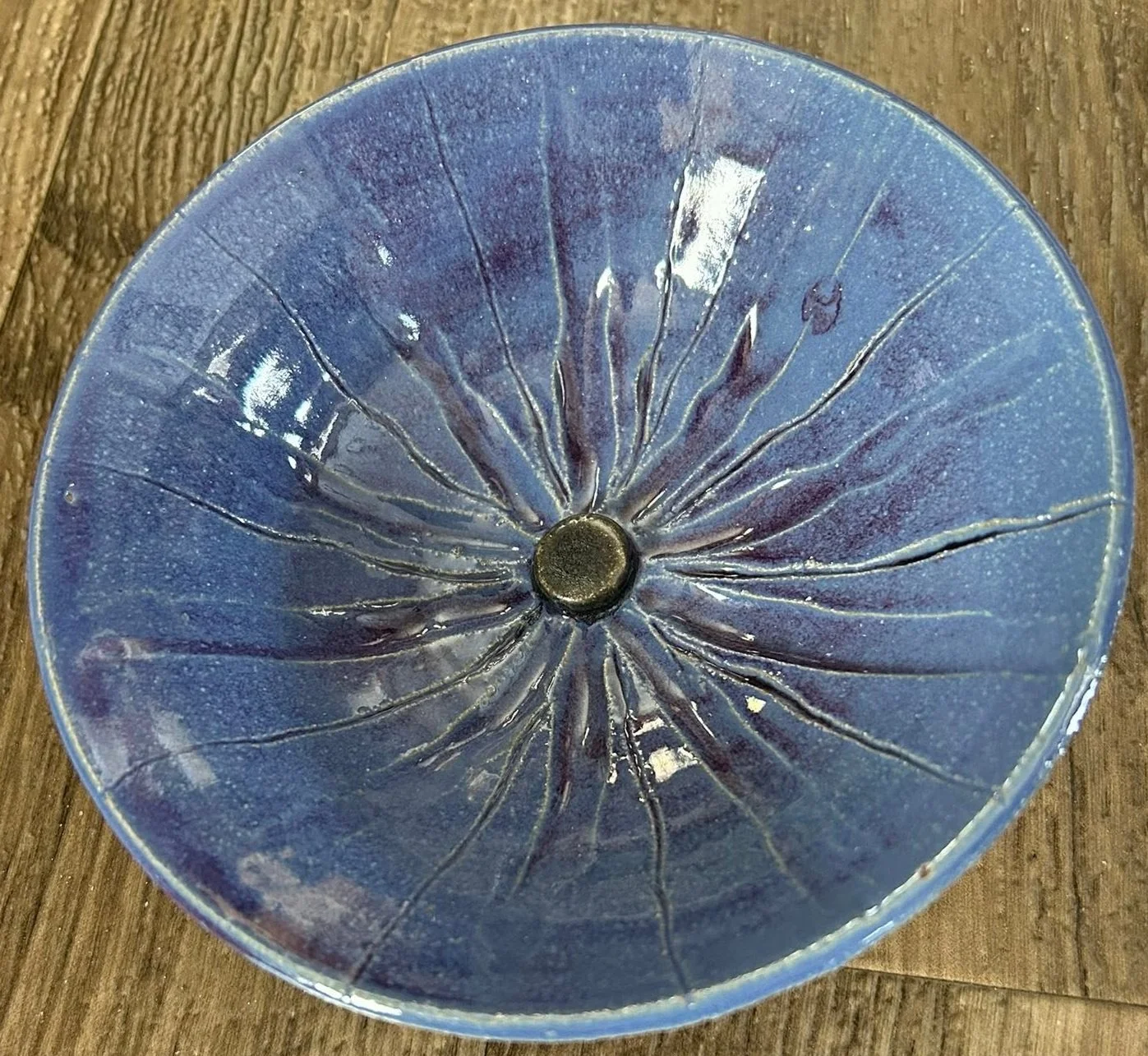 Handmade ceramic bowl with blue glaze and textured radiating pattern crafted by Purple Moon.