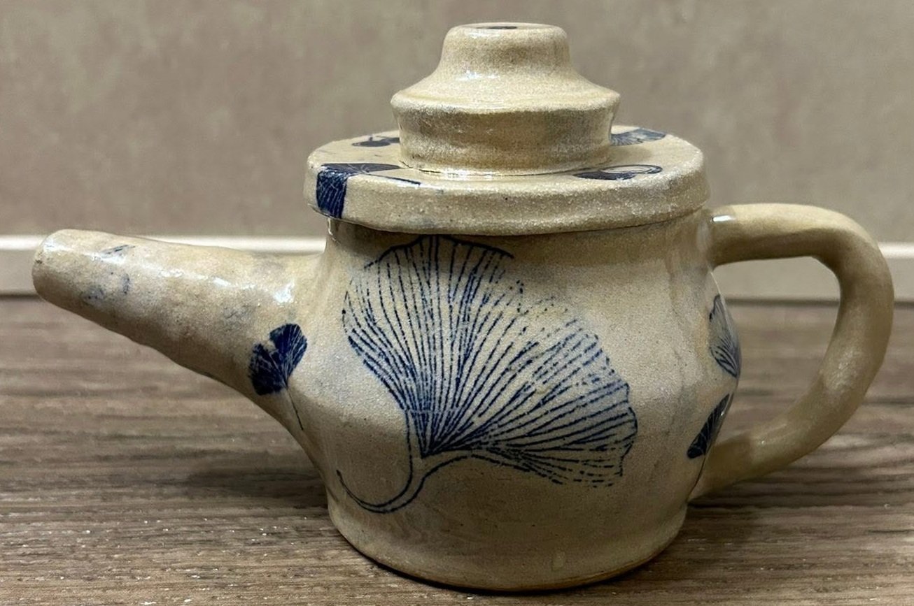 Handmade ceramic teapot with tan glaze and blue ginkgo leaf designs crafted by Purple Moon.
