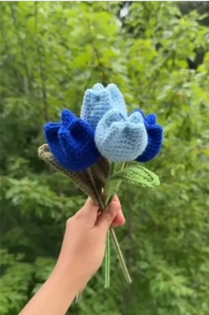 Handmade crochet tulip bouquet in blue shades with green stems, crafted by Meraki The Soul Creativity and photographed outdoors in Waterloo, Iowa.