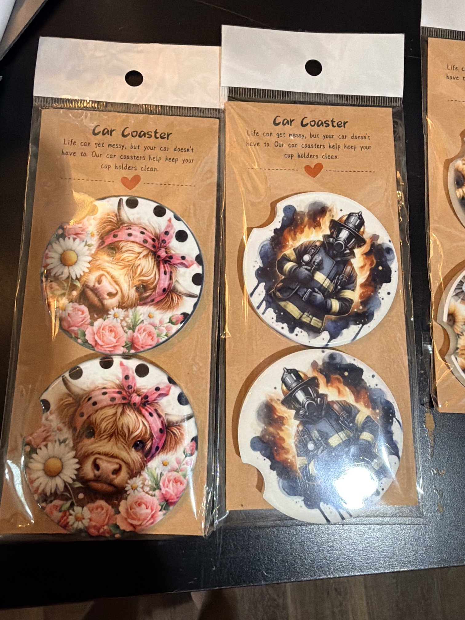 Handmade car coasters featuring firefighter and highland cow designs.