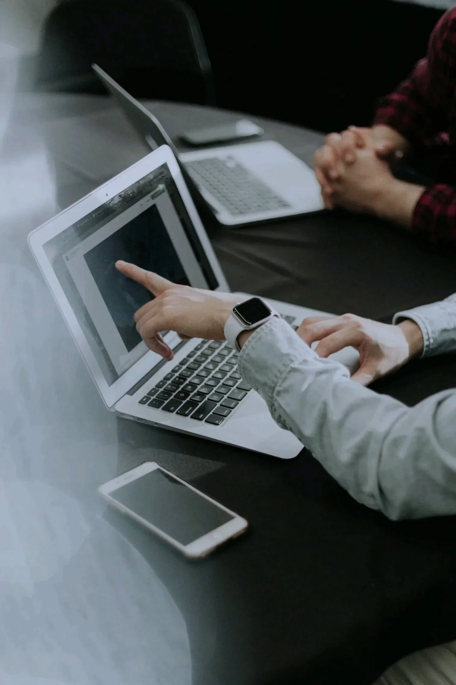 Business consultant and small business owner working together on laptops. Showing only hands and laptops on a desk.