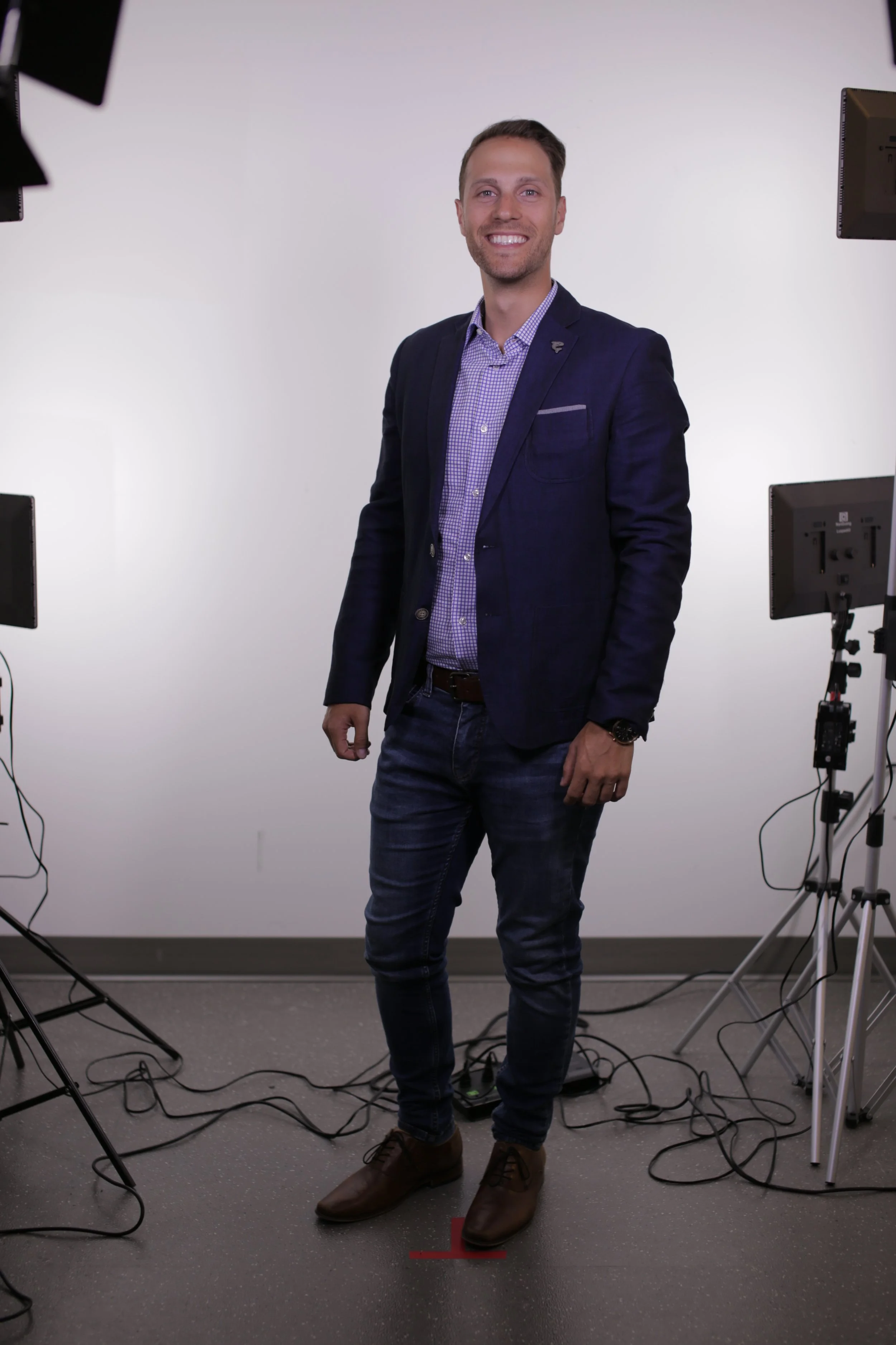 Anthony D'Apice, small business consultant in Montreal, standing in a suit jacket and jeans, smiling.
