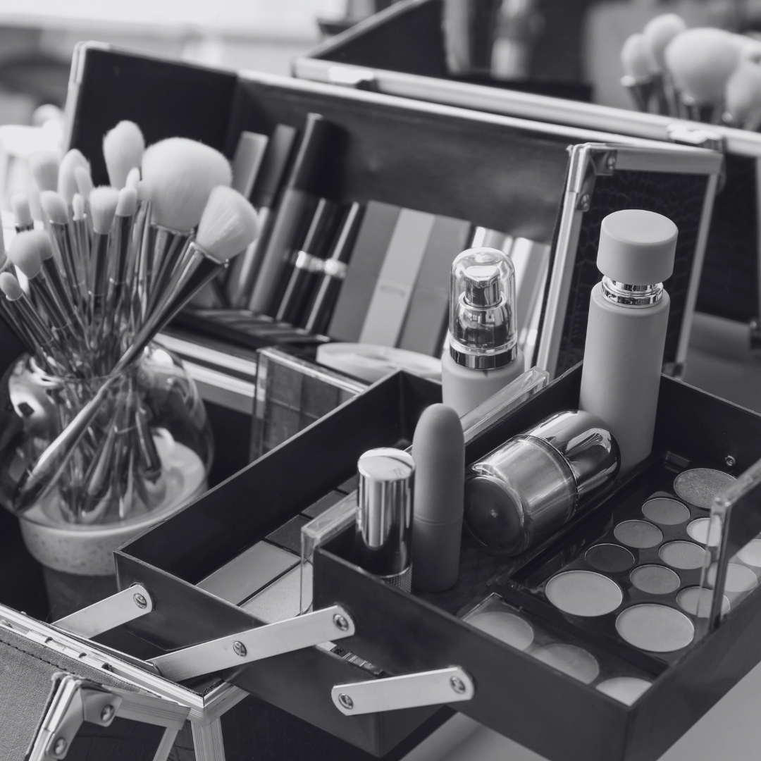 A collection of makeup brushes and cosmetics organized in containers on a table.