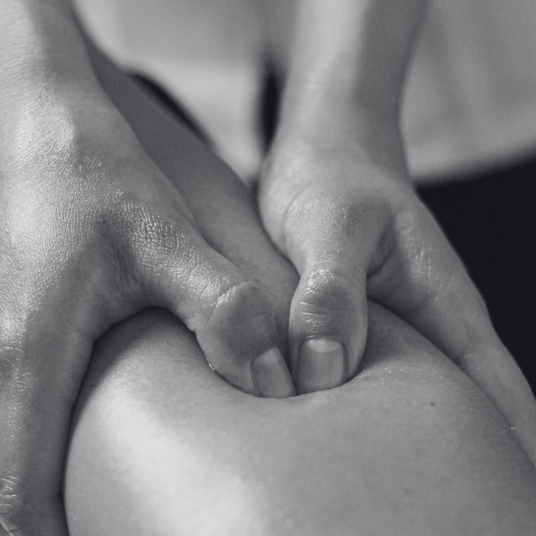 Close-up of a massage therapist's hands applying pressure on a person's back.