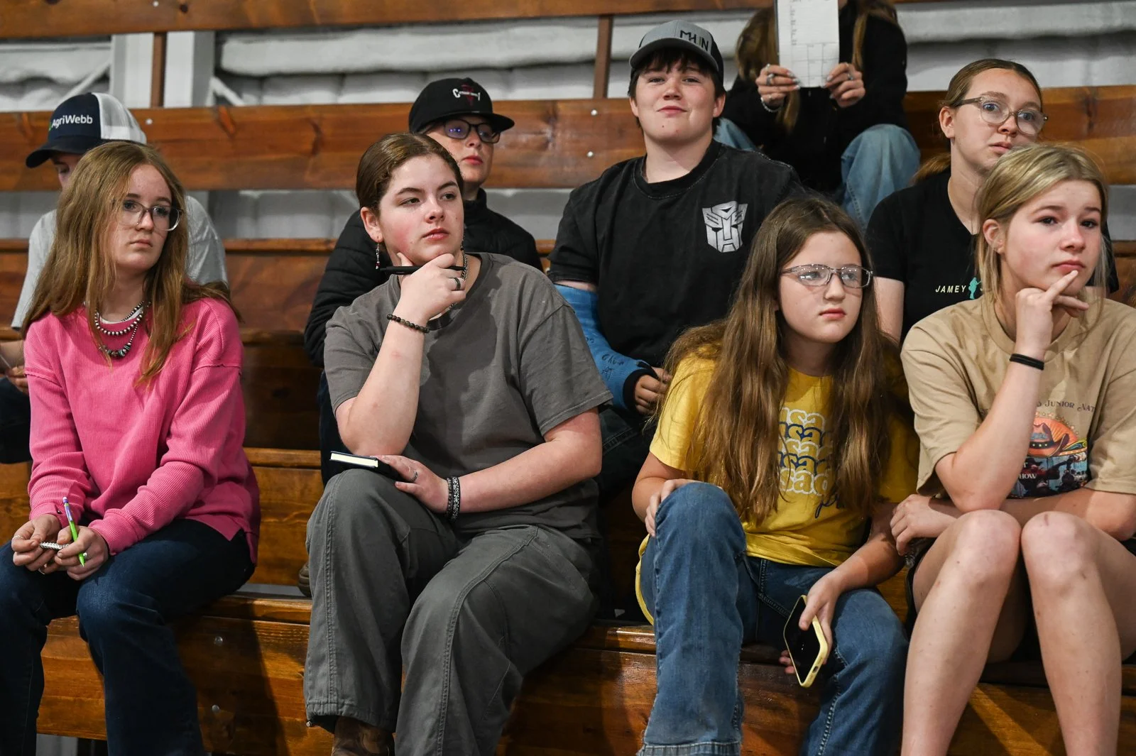 Group of young people sitting on wooden bleachers at the Miniature Hereford Junior Nationals