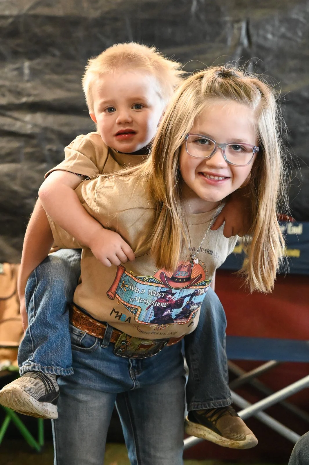 a sister gives her brother a piggy back ride at the Miniature Hereford Junior Nationals.  The Miniature Hereford Junior Nationals is a fun family event where all can participate