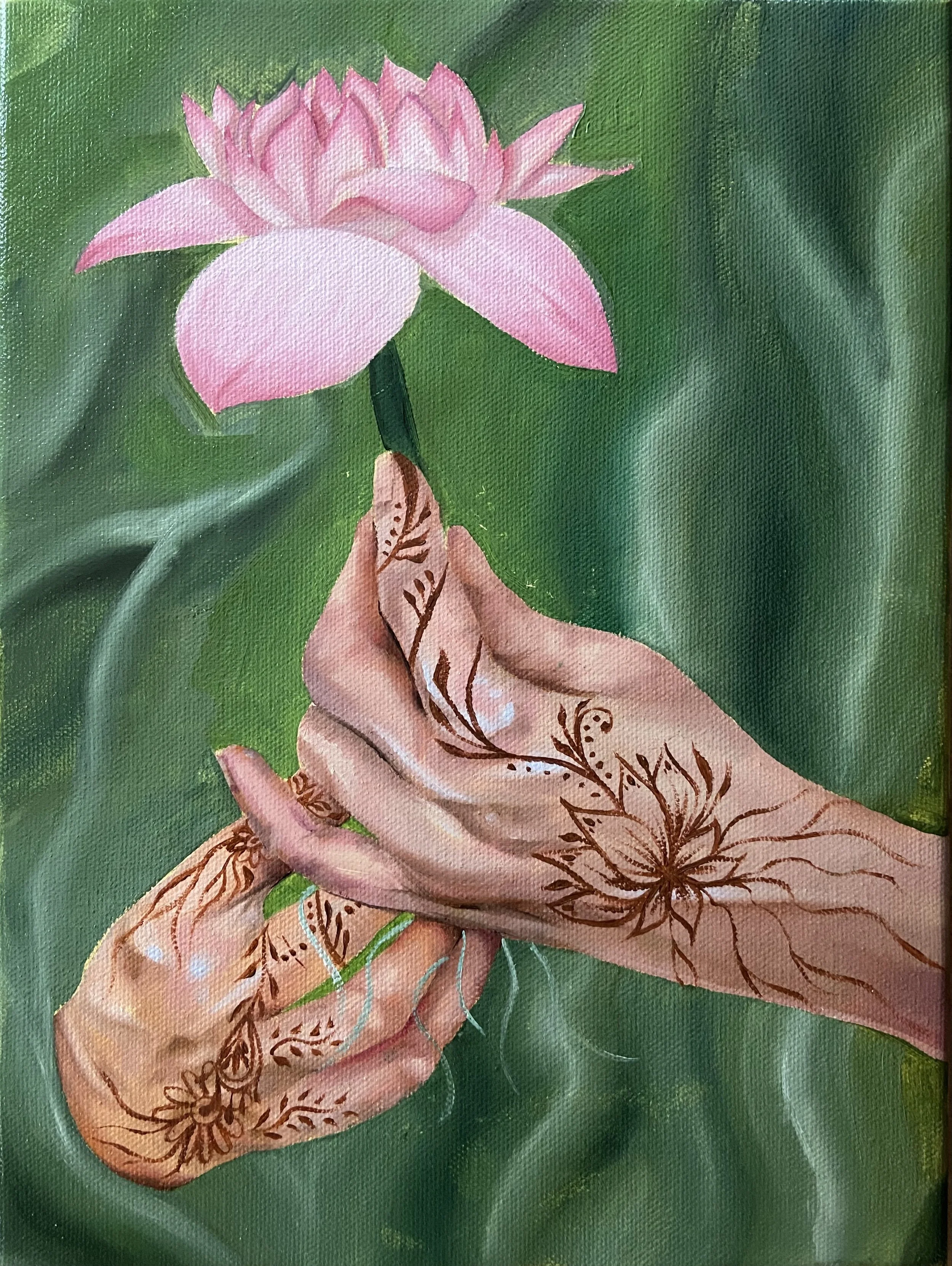 A hand with henna designs holding a pink lotus flower above a green background.