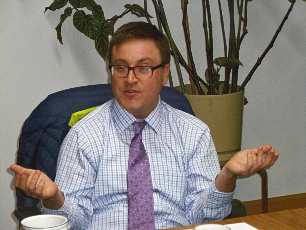 man sitting down, speaking