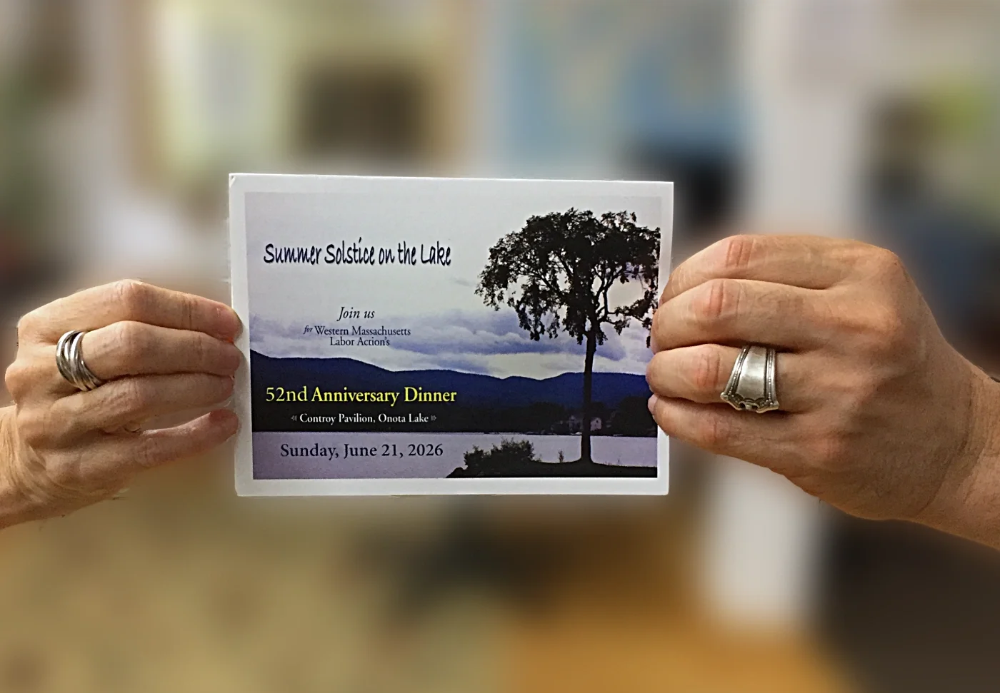 two hands holding up an invitation