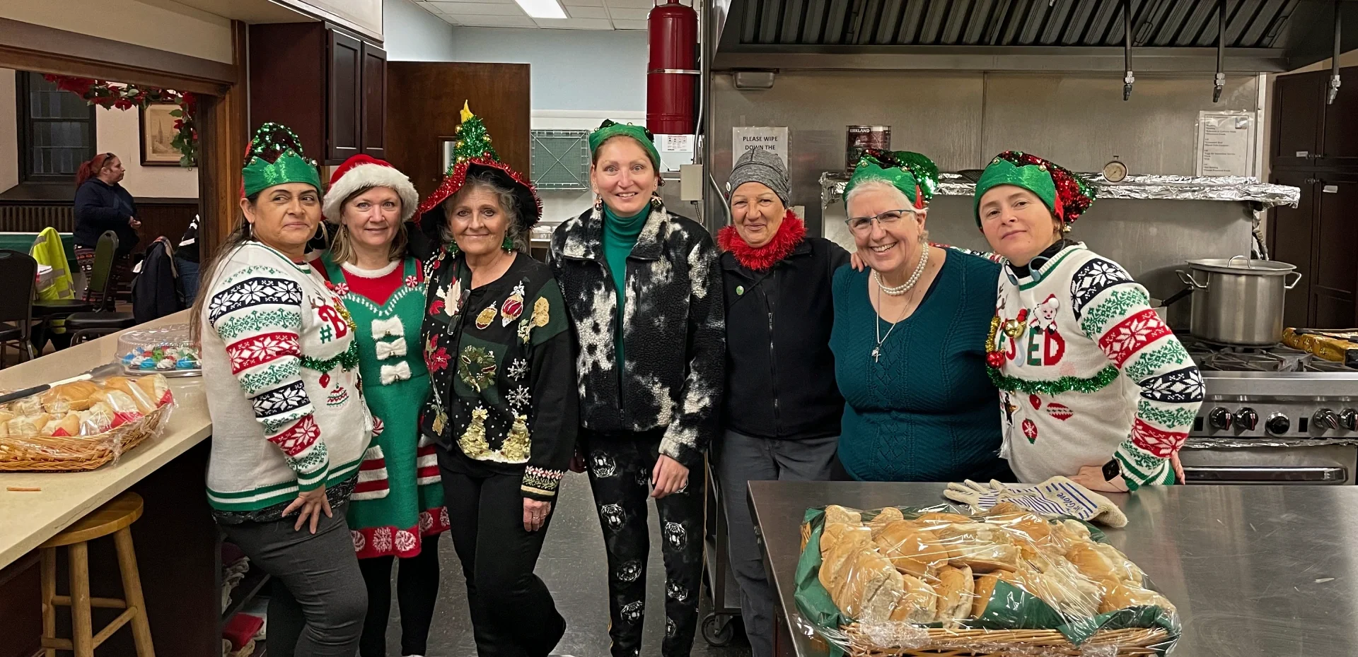 seven women dressed in holiday garb, red and green.