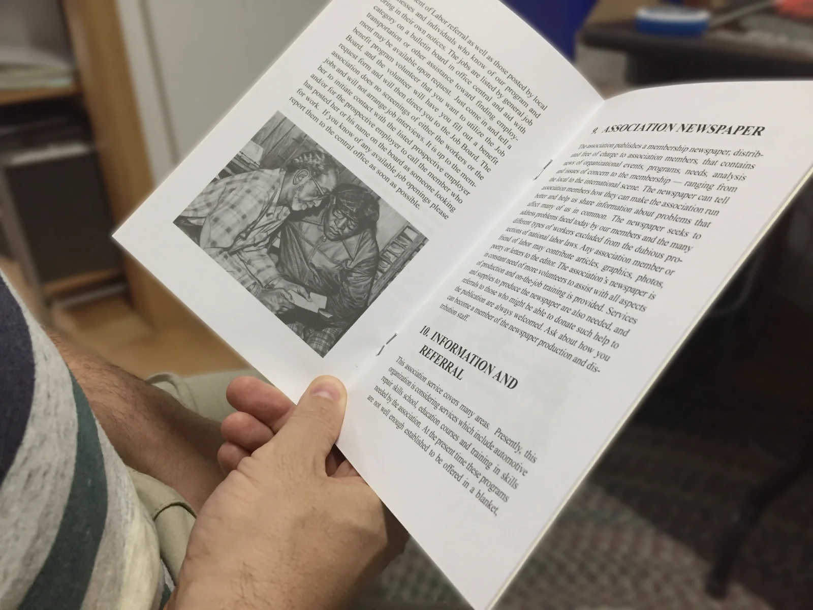 a hand holding up a benefit booklet