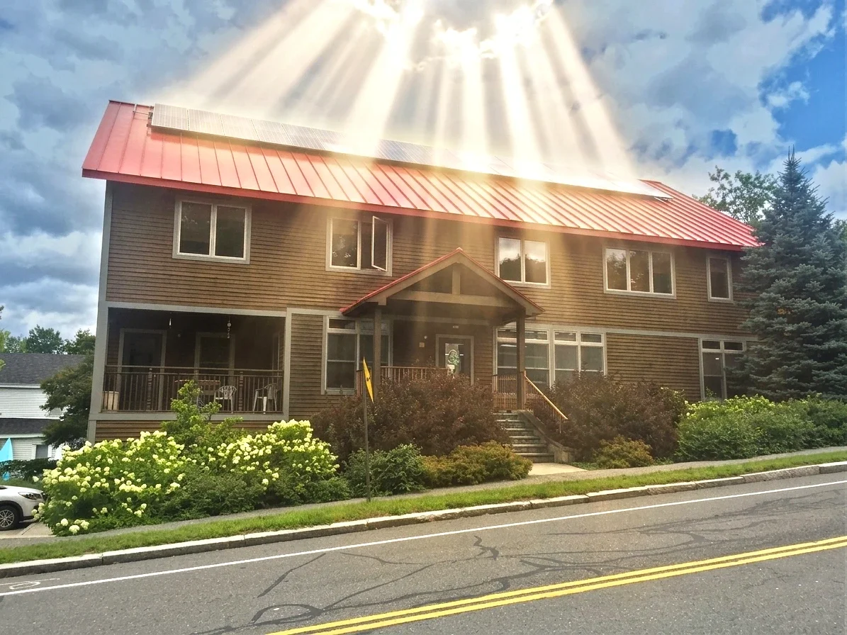 A shining light with "god rays" coming down from the sky onto WMLA's Office Central's solar panels.