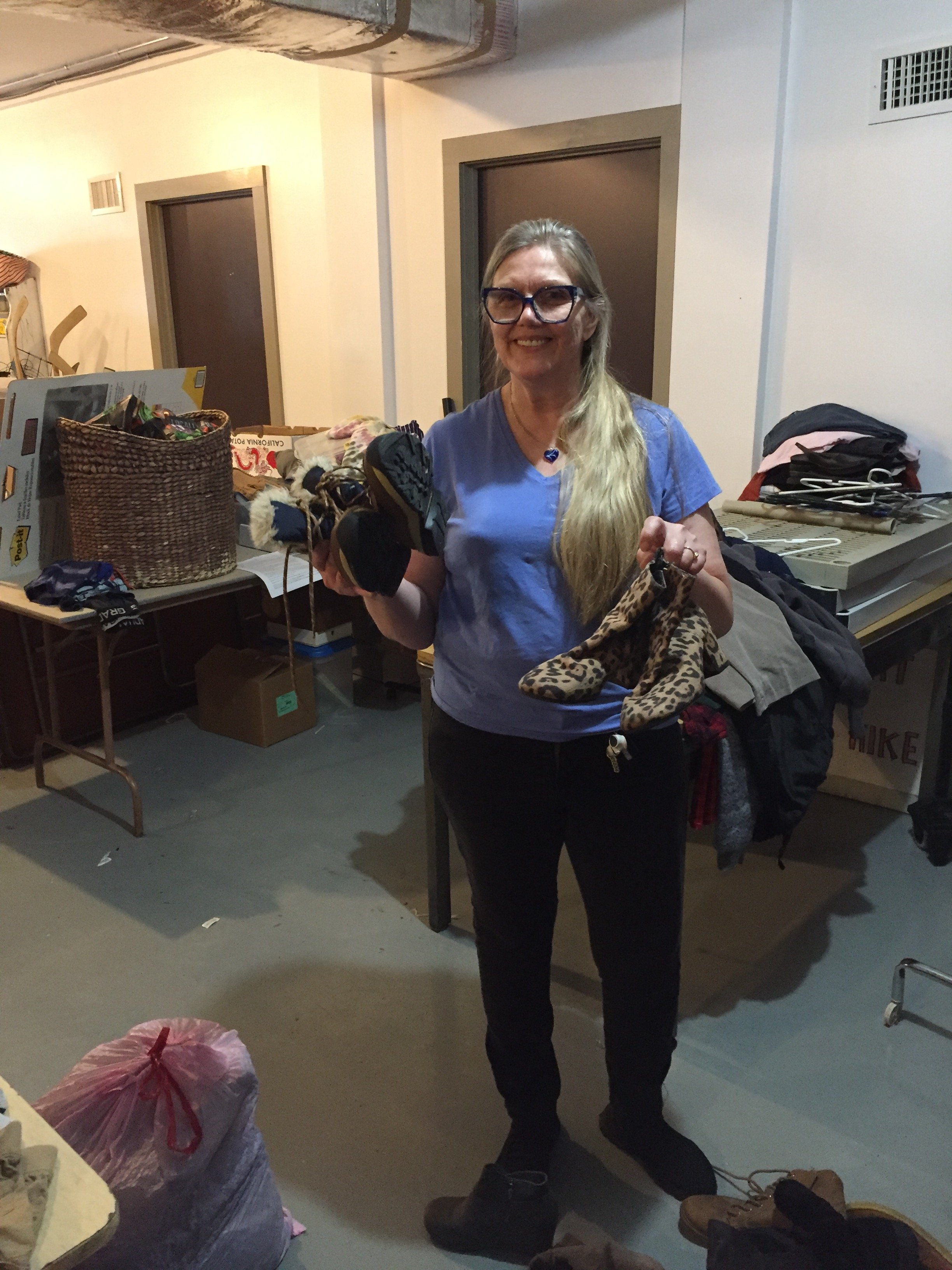 Woman holding up two pairs of shoes