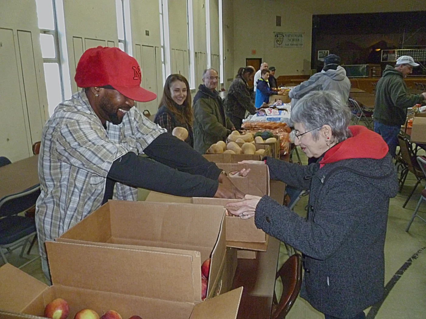 A row of volunteers packing Thanksgiving food from boxes