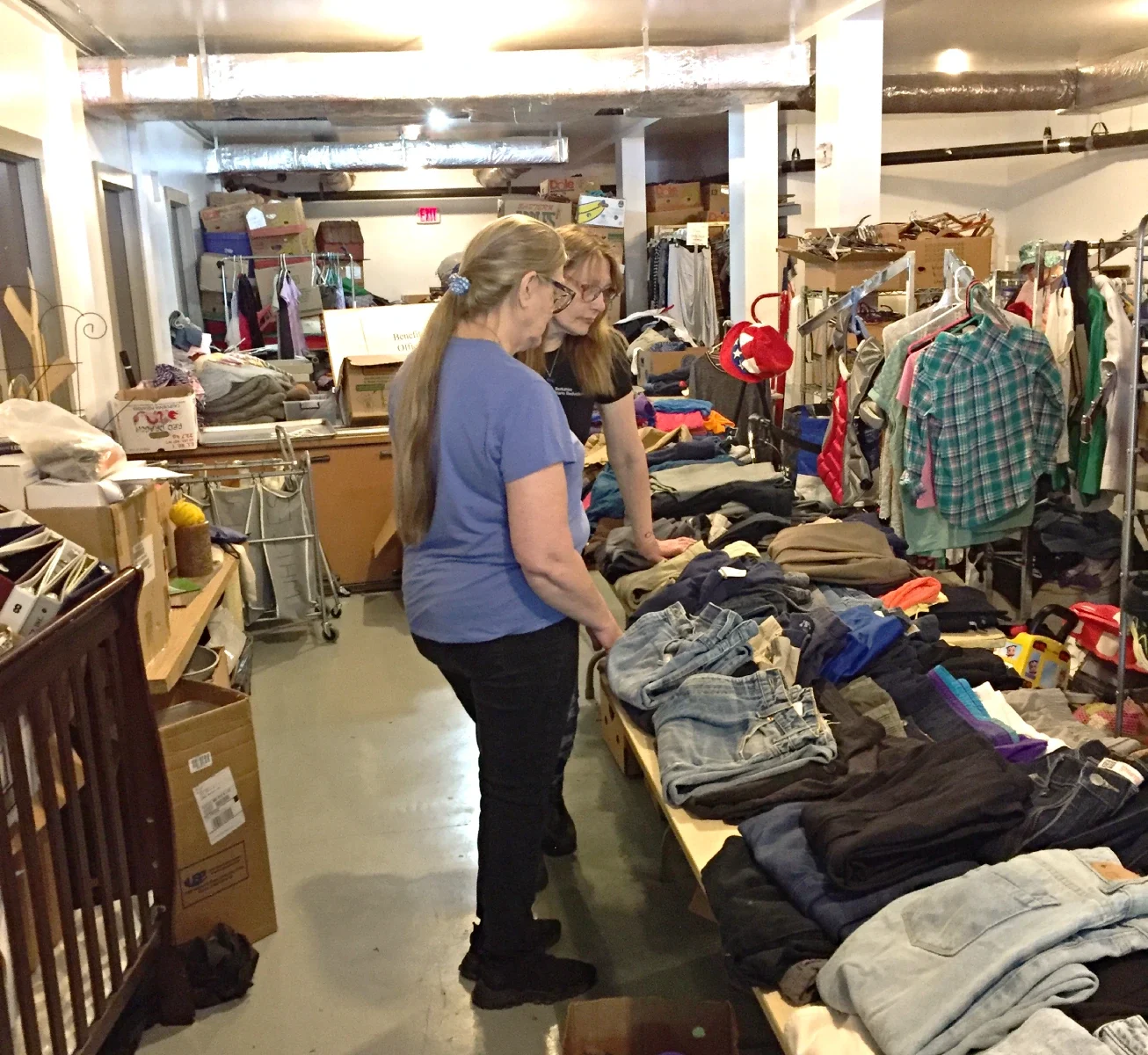 A woman standing with a rack of clothing