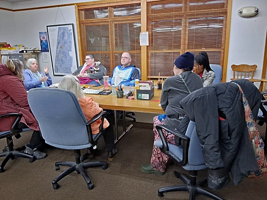 seven people meeting around a table