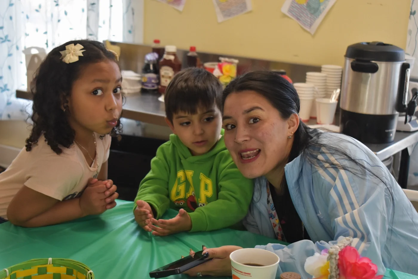 A photo of a WMLA member and two young children at a spring party.