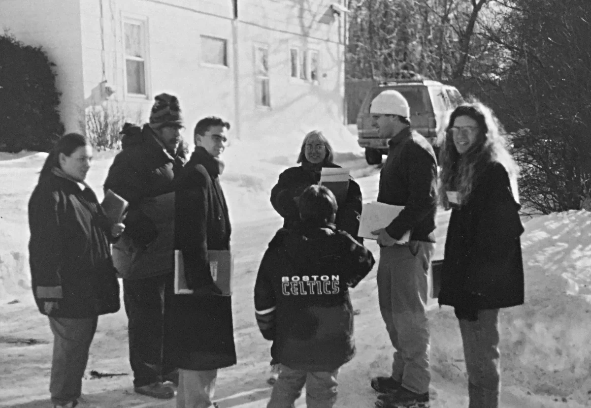 A historical photo in black and white of a groupf of WMLA volunteer with clipboards on a snowy street preparing to canvass.
