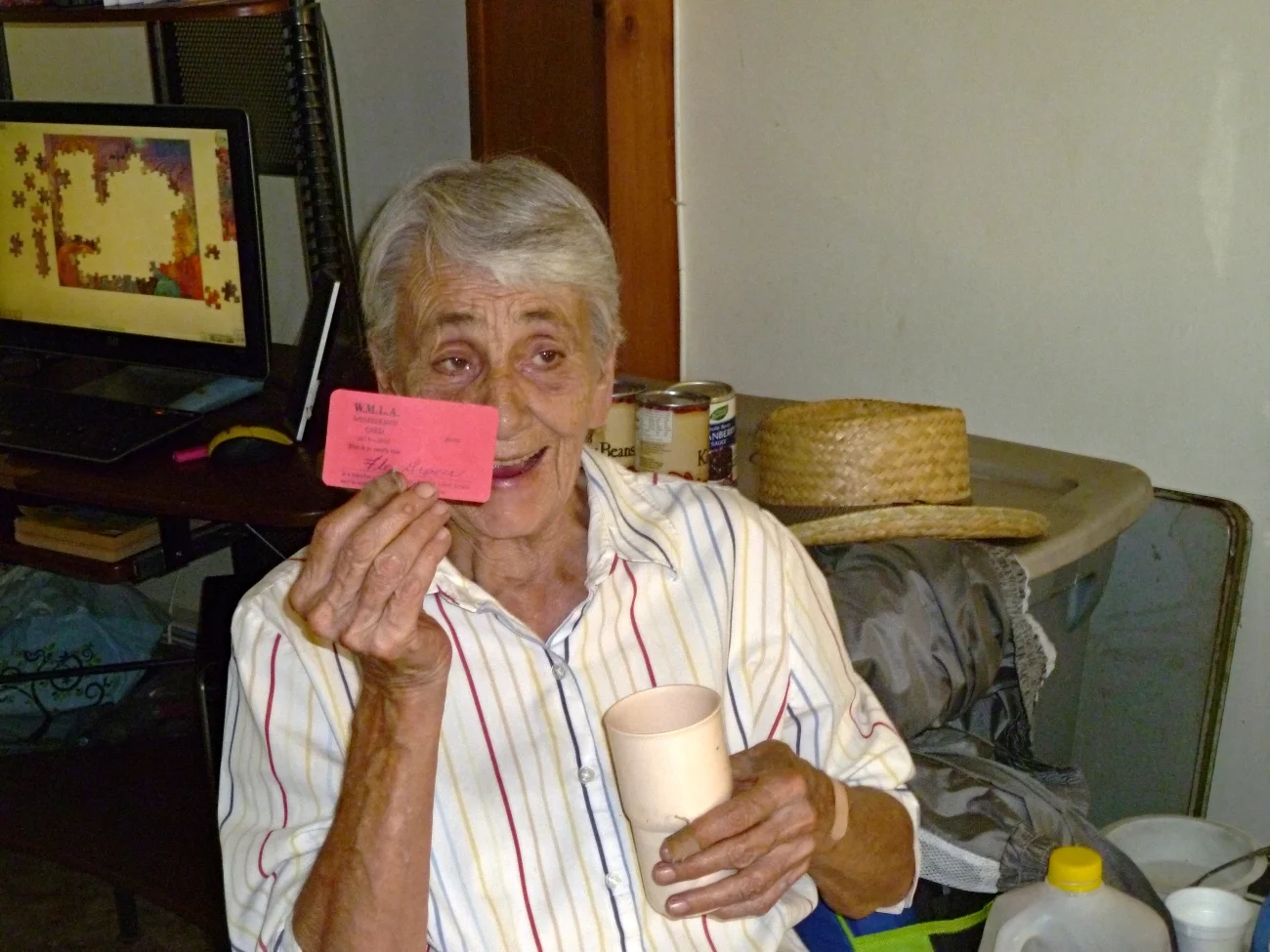 A woman holding up a red membership card