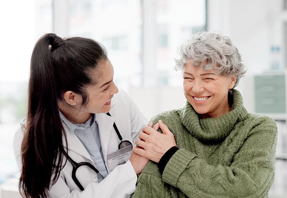 Caring physician interacts with smiling patient.