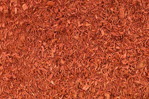 Close-up image of red wood mulch or shredded bark used for landscaping.