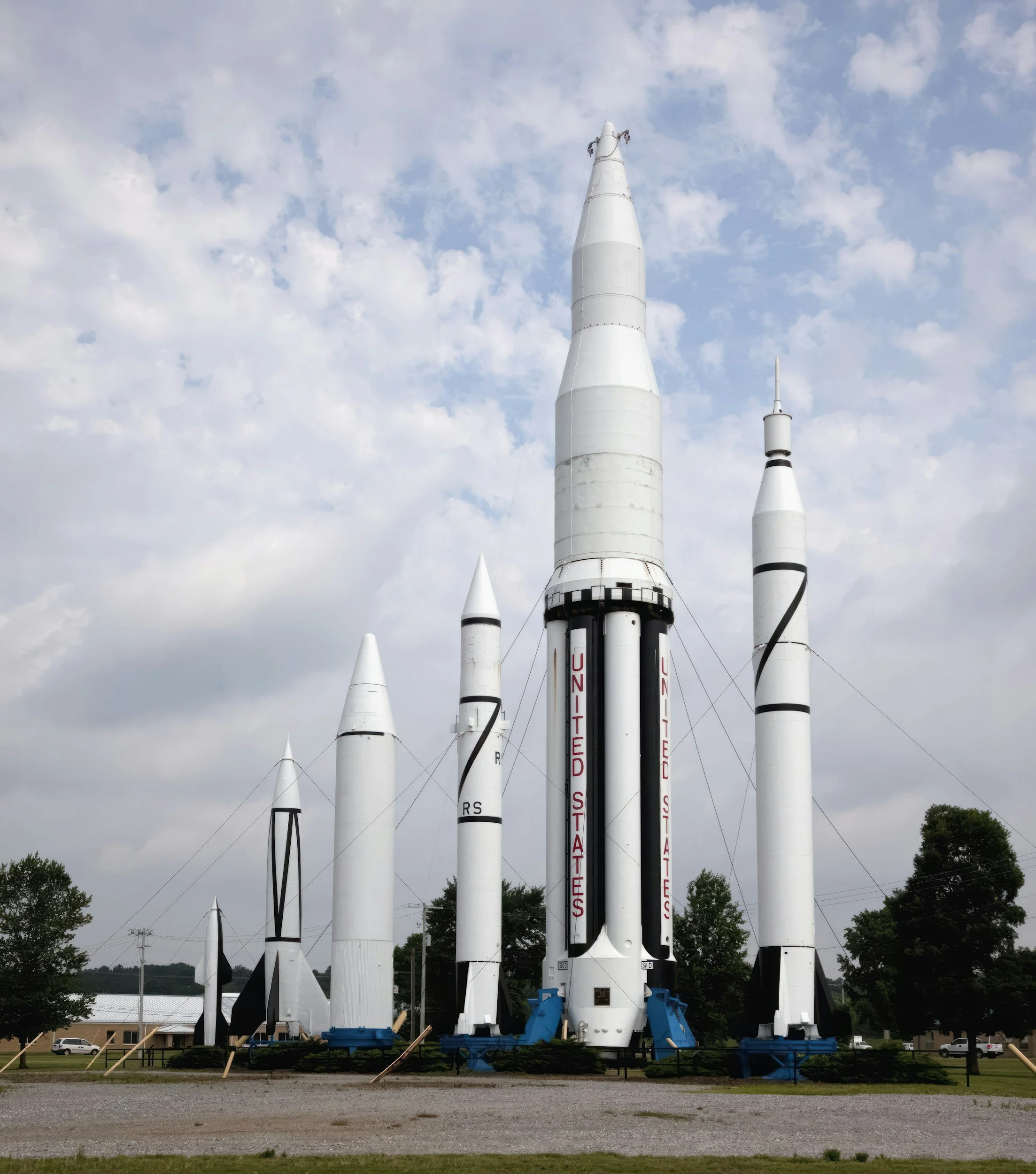 Various rockets standing upright outdoors on a cloudy day, some with 'UNITED STATES' written on them.