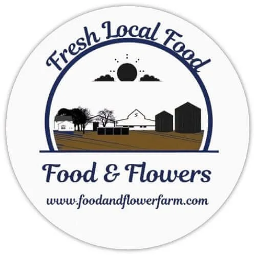 Logo for Food and Flowers farm, featuring a sunrise or sunset over trees, barns, and farm buildings, with the text "Fresh Local Food" and "Food & Flowers" and the website www.foodandflowerfarm.com.