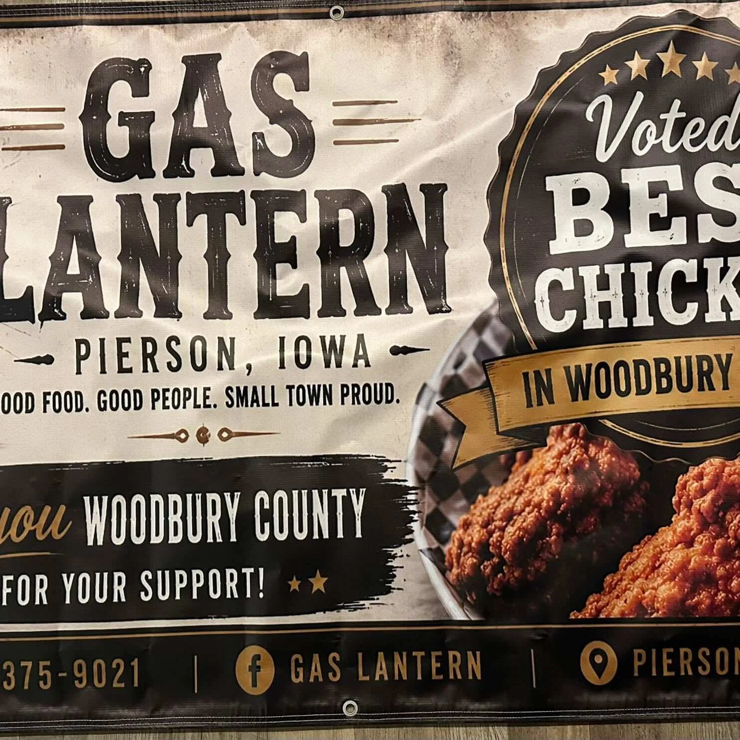 Sign promoting GASF from Pierson, Iowa, featuring fried chicken with text 'Voted Best Chicken in Woodbury,' and mentioning support for Woodbury County, with phone number, Facebook and location icons.