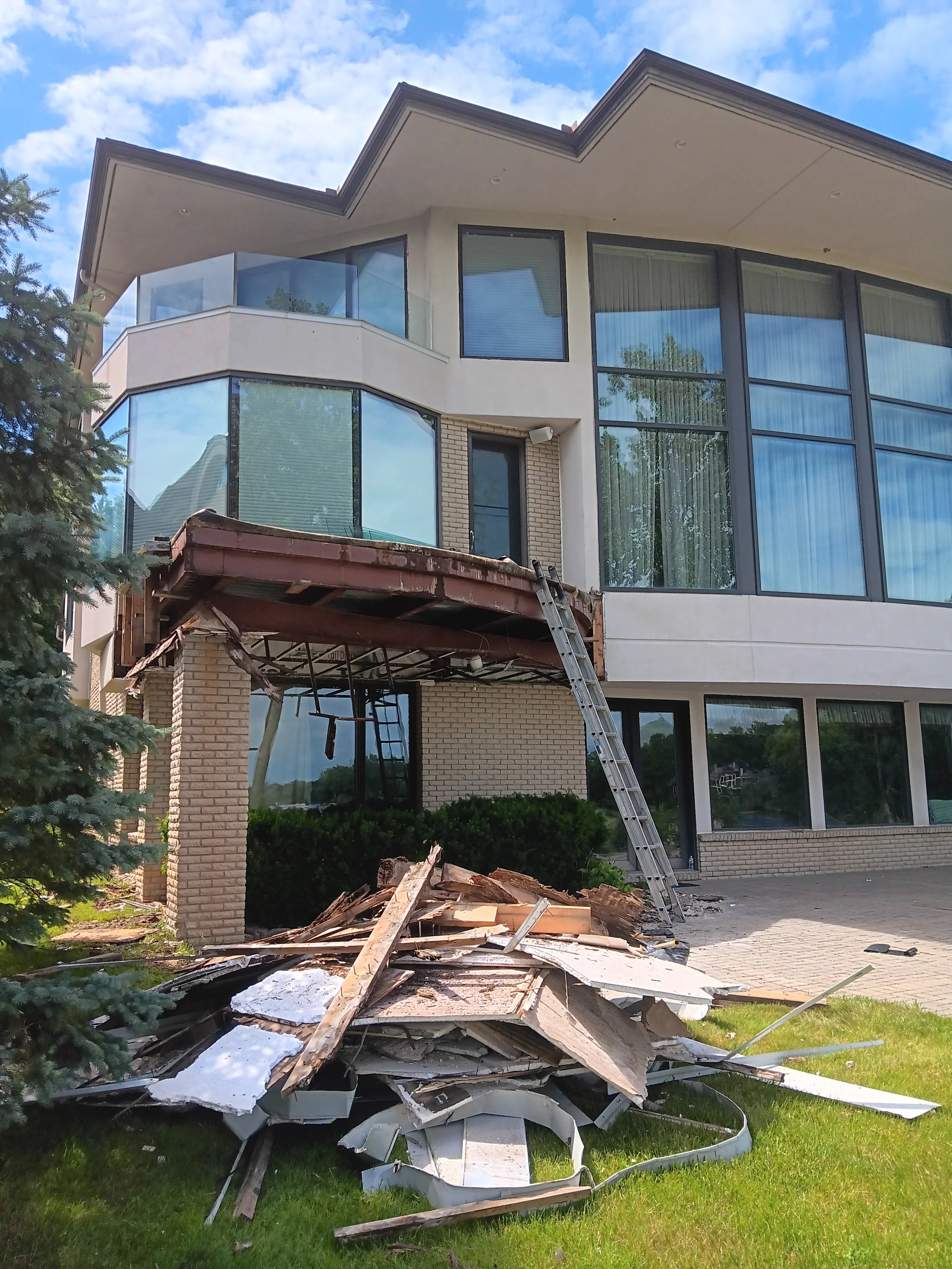 Exterior view of a Rochester Hills home during demolition and reconstruction of the curved balcony.