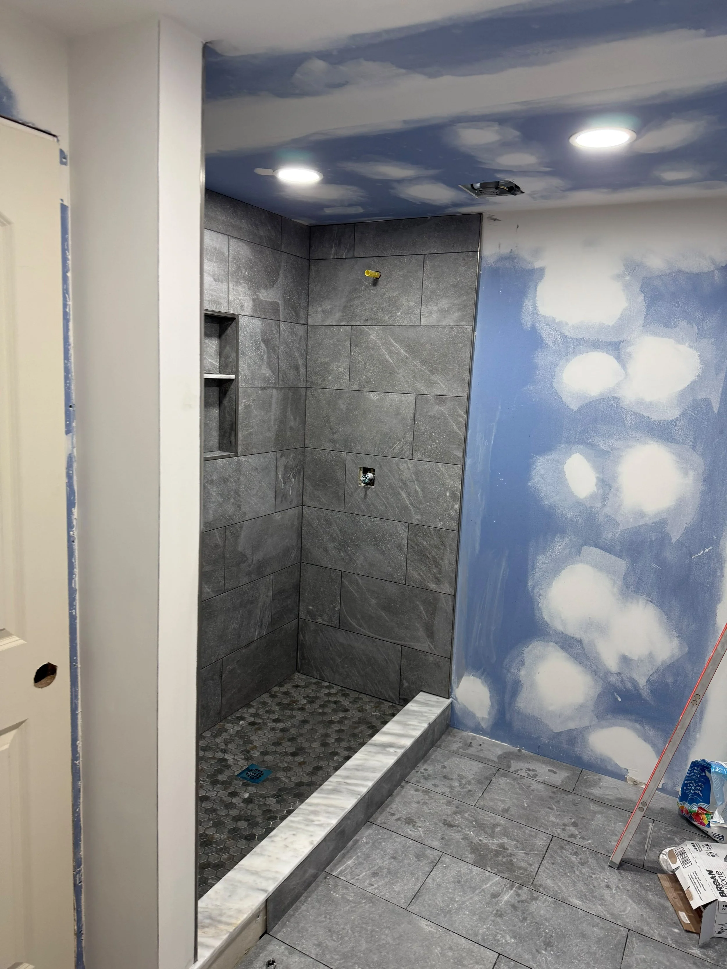 A clean and modern entrance leading into a beautifully remodeled bathroom with premium finishes and recessed lighting.