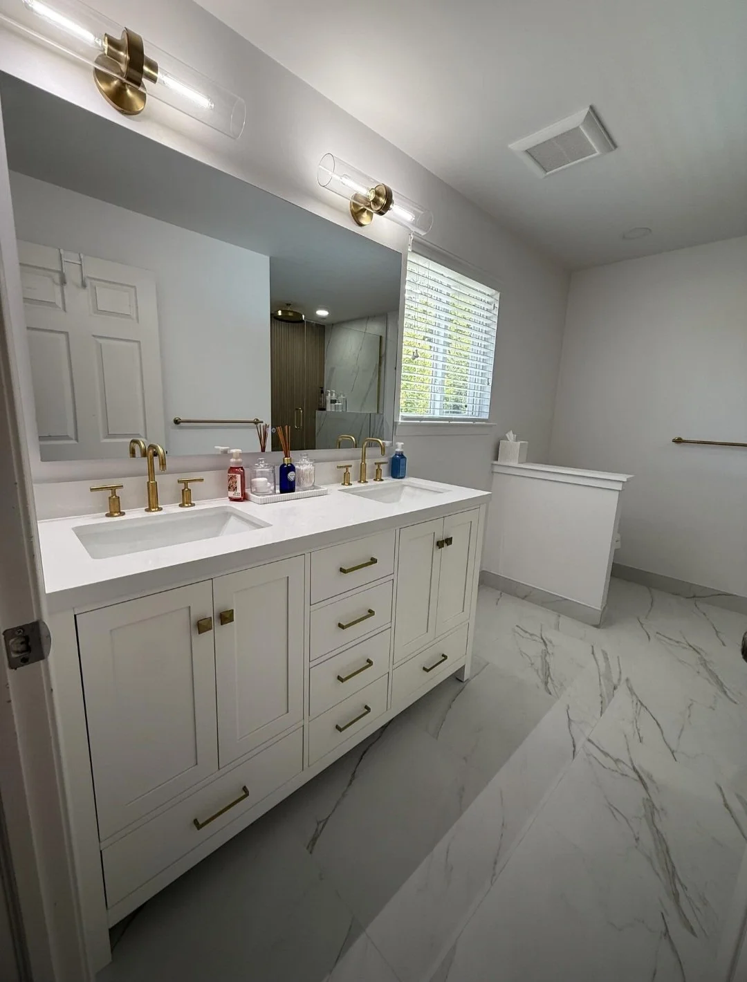 A custom double-sink with vanity quartz countertops, stylish lighting, and generous storage creates a clean and sophisticated centerpiece.