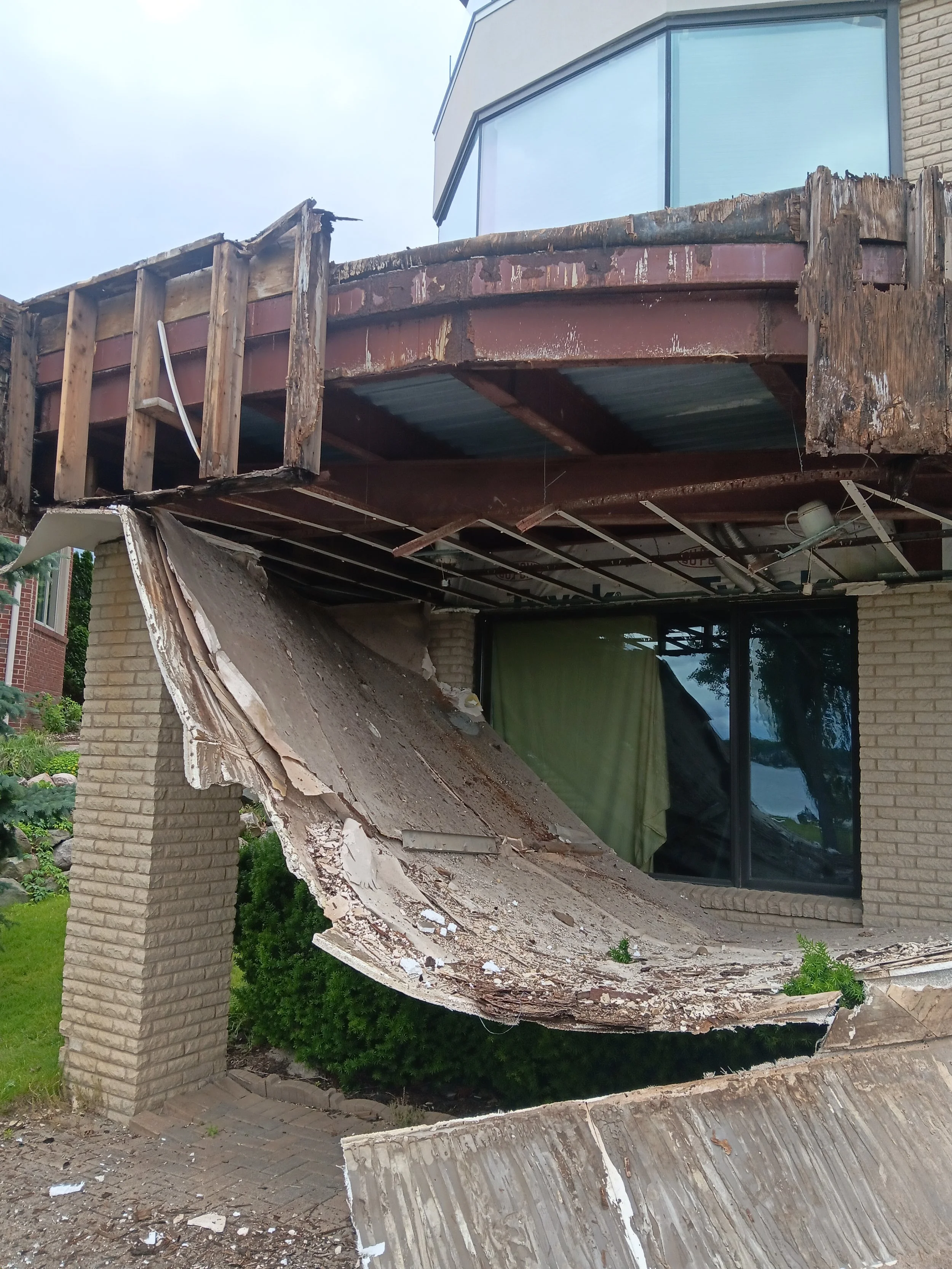 Damaged curved exterior balcony during demolition and structural repair work in Rochester Hills, MI.
