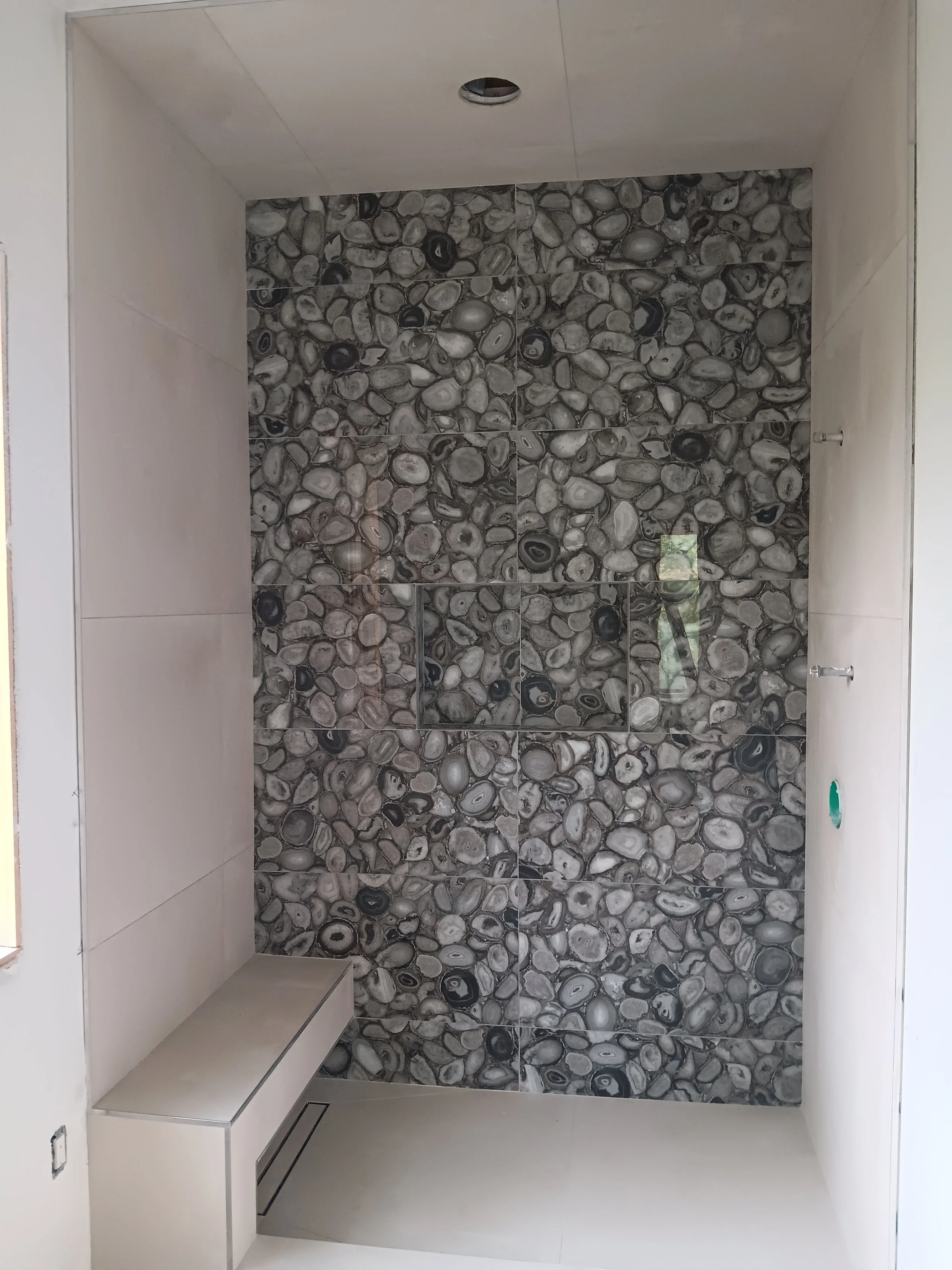 Custom shower niche finished with coordinating tile for convenient storage.