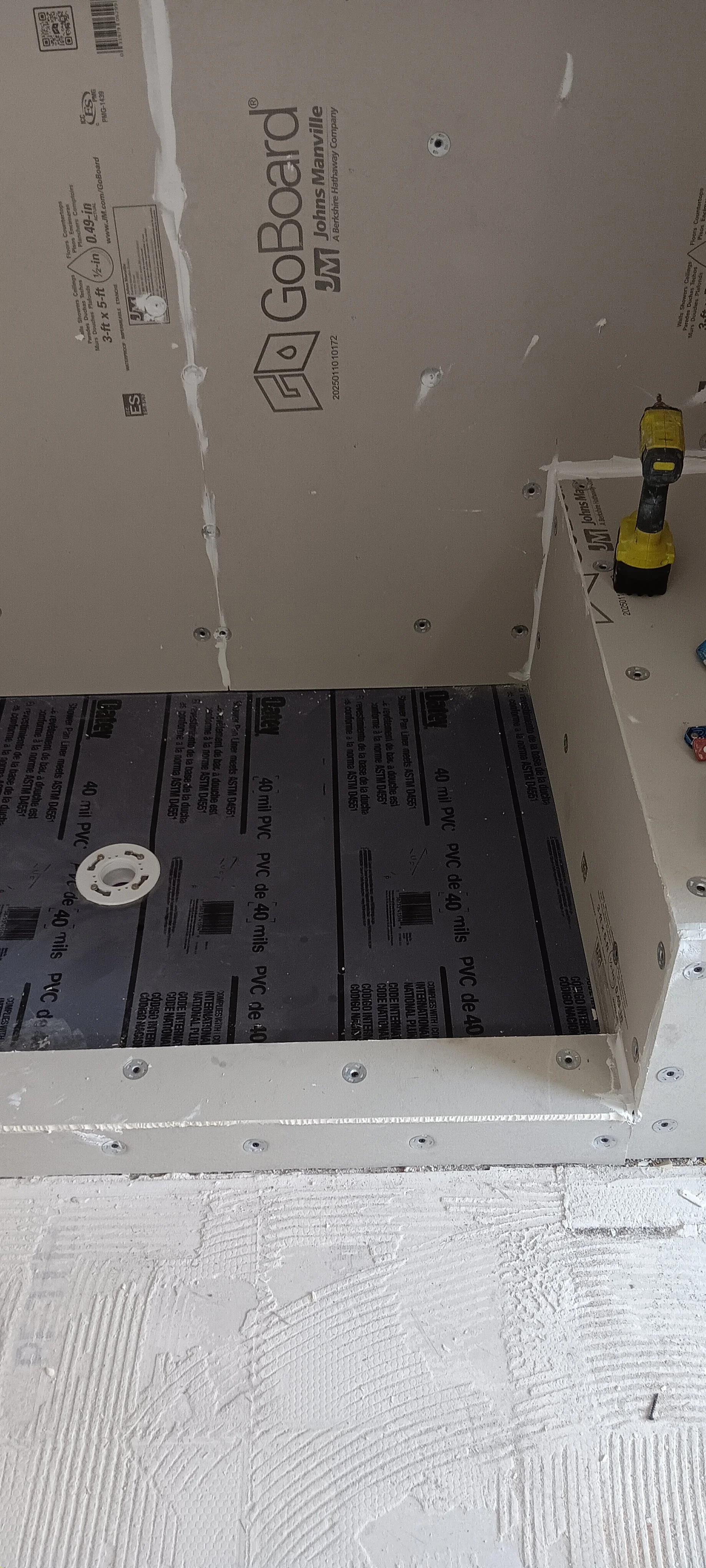 Shower walls covered with cement board and the base prepared for waterproofing.
