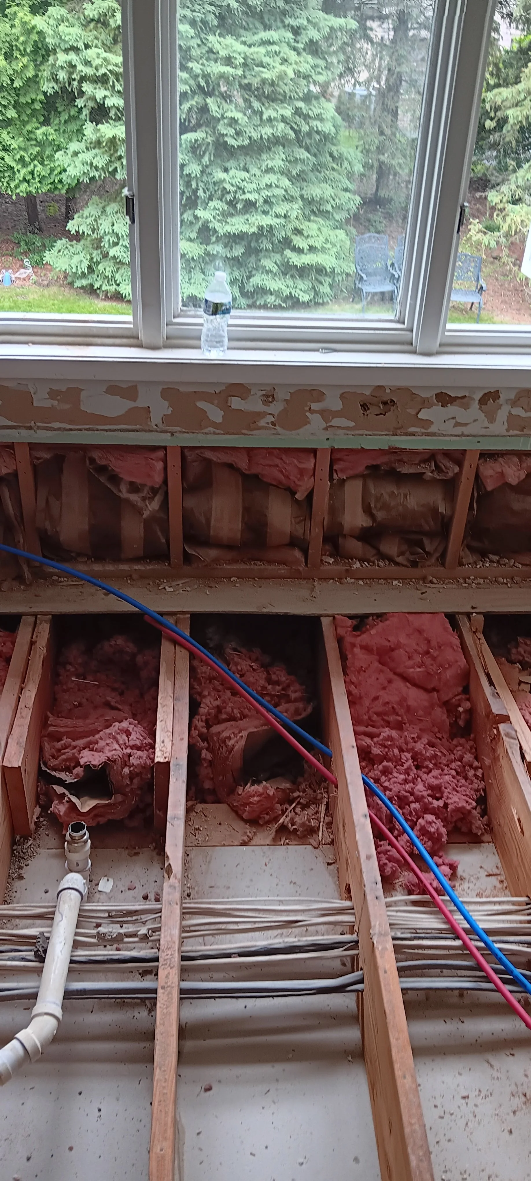 Bathroom plumbing and framing exposed in preparation for reconstruction.