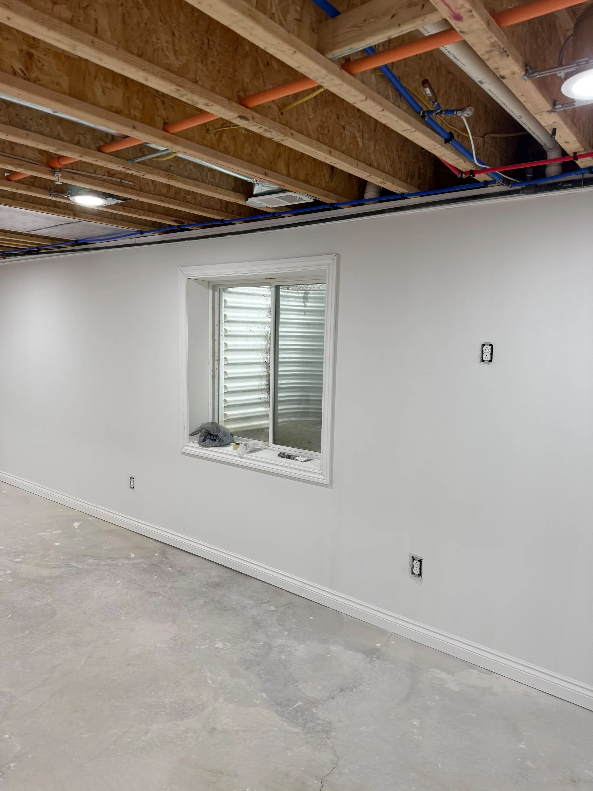 Freshly finished walls and recessed lighting transform the basement into a bright, comfortable, and versatile living area.