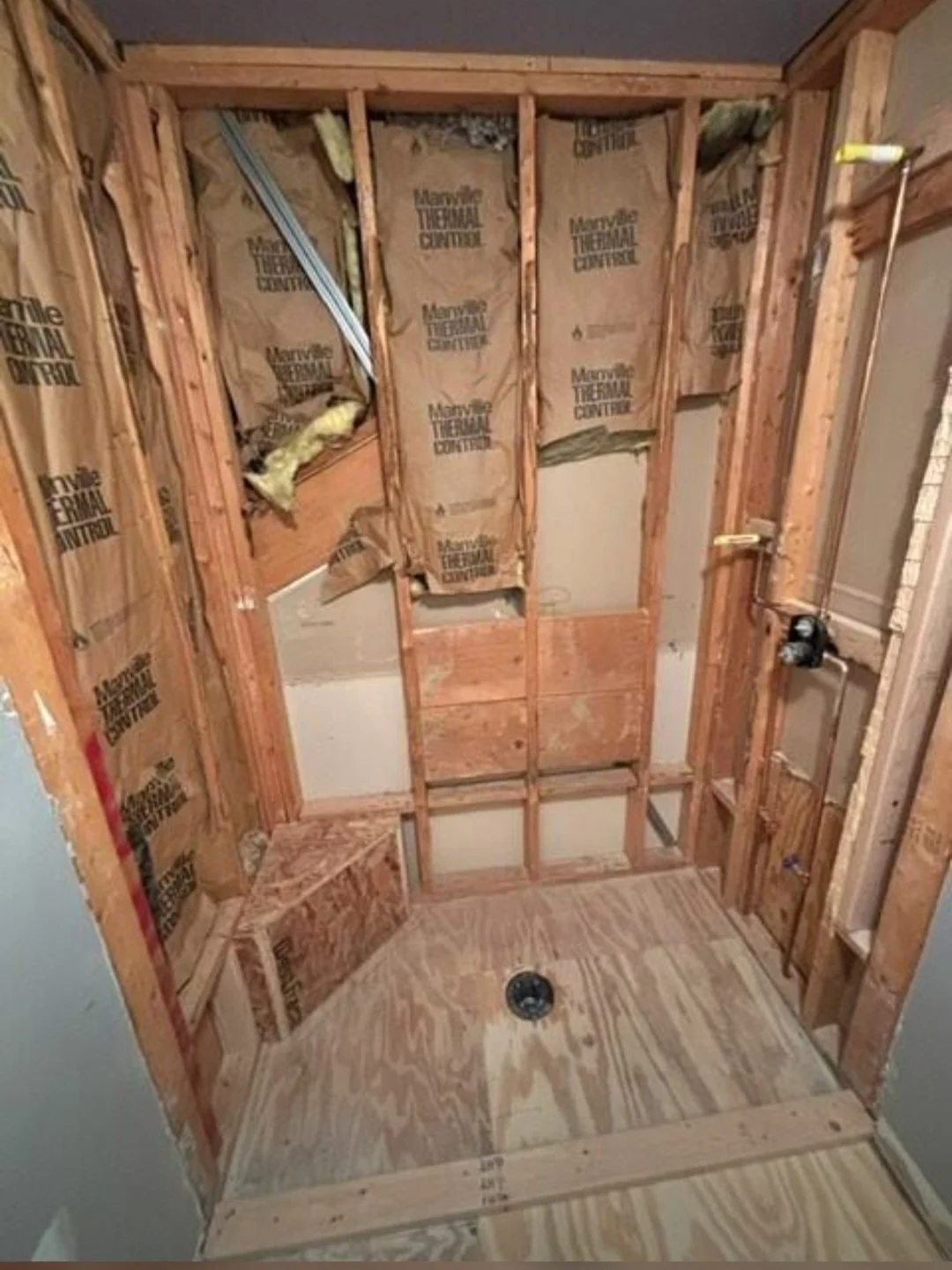 The shower has been stripped down to the framing, allowing for new plumbing, waterproofing, and a durable installation.
